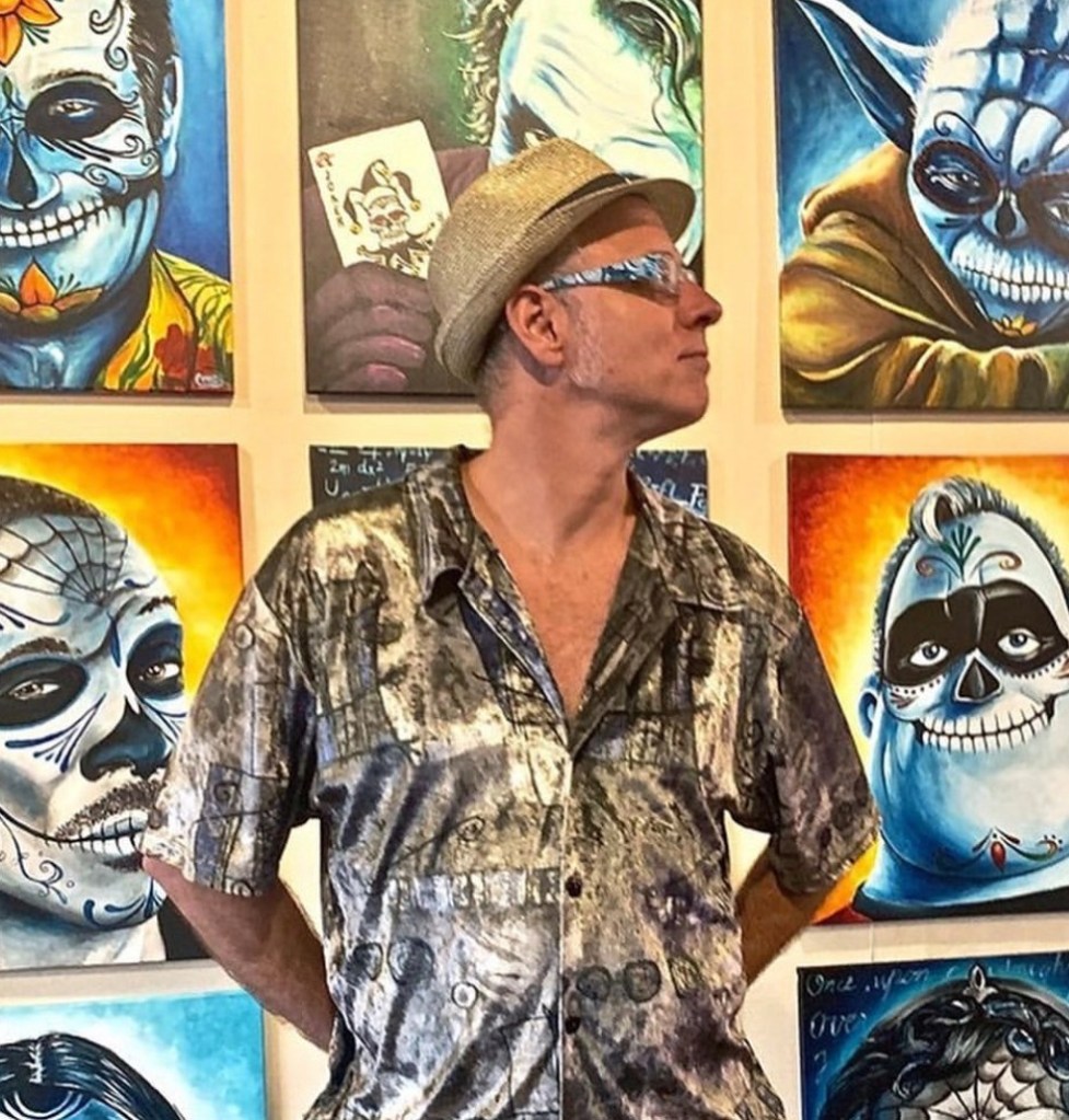 David Cruey standing among his Pop Skullture paintings.