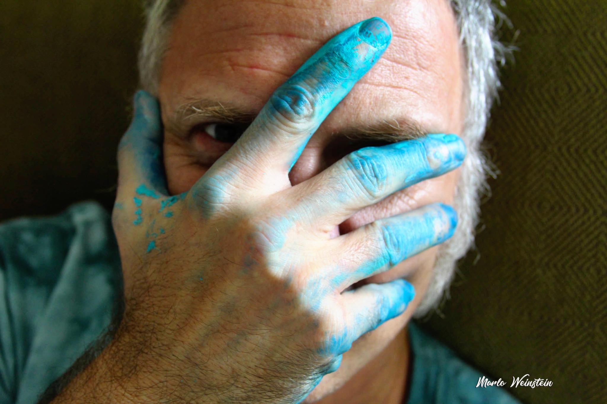 David Cruey with blue paint across his hand and face.